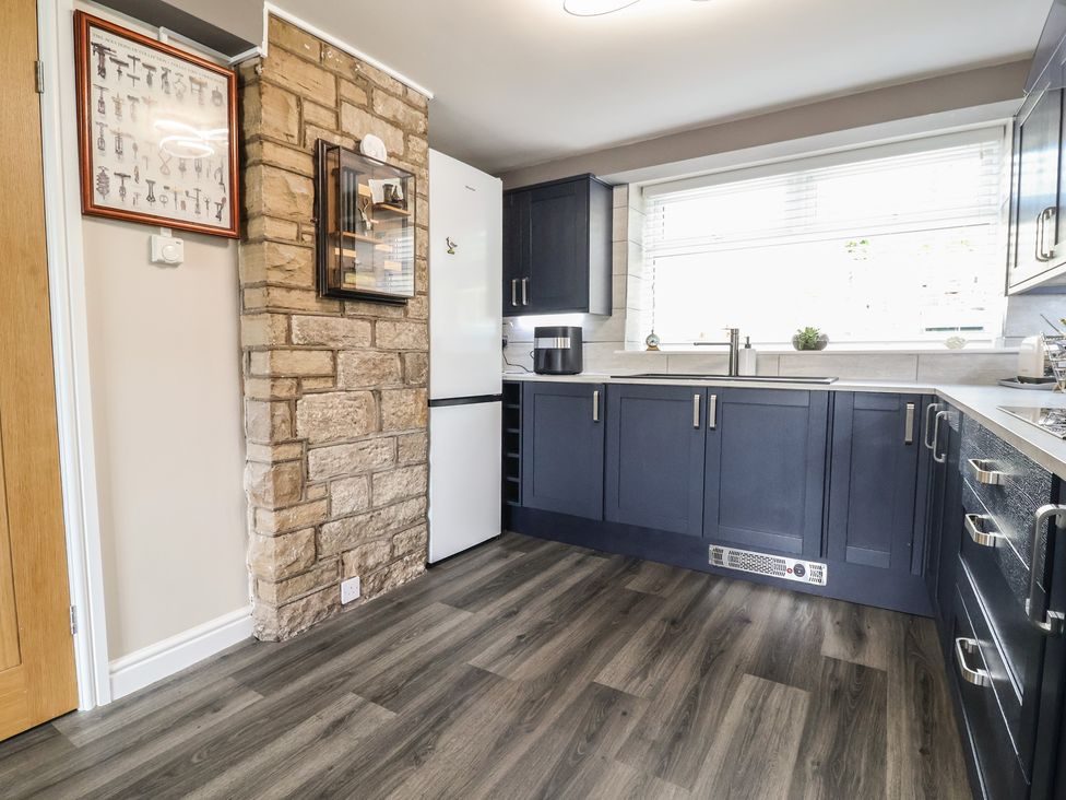 Kitchen with navy shaker units, integrated oven and microwave