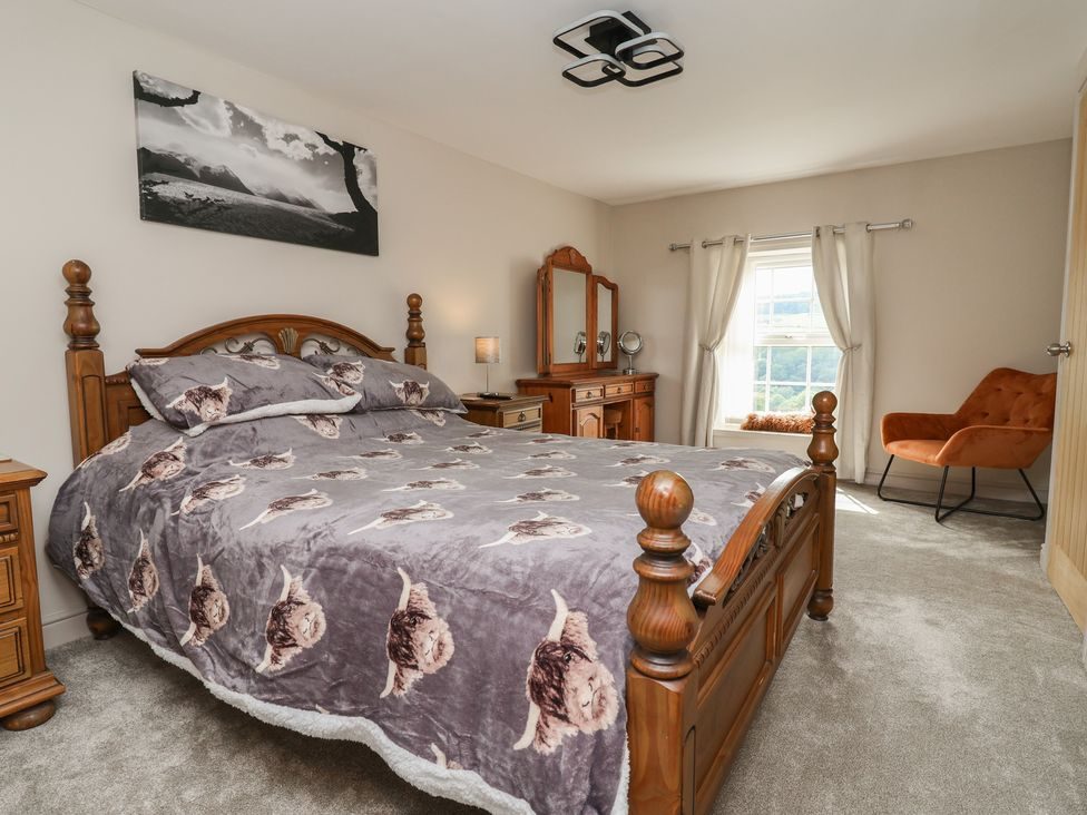 King-size bedroom with carved wooden bed beside the window
