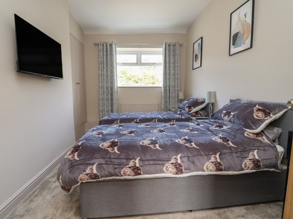 Twin bedroom with wall-mounted TV