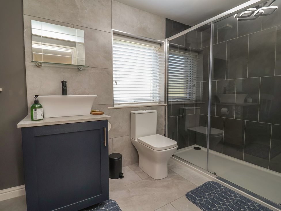 En-suite shower room with walk-in glass shower and counter-top basin